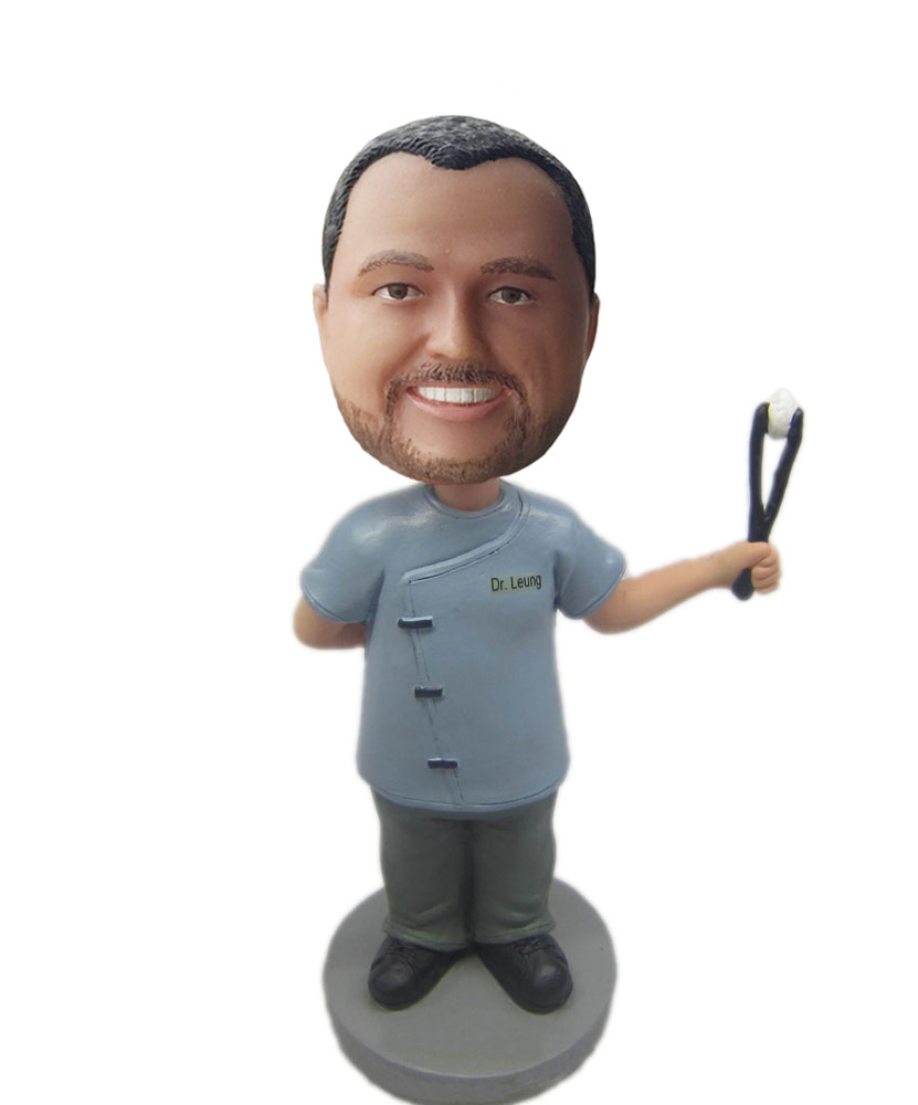 Doctor bobbleheads holding up with a operating forceps B239