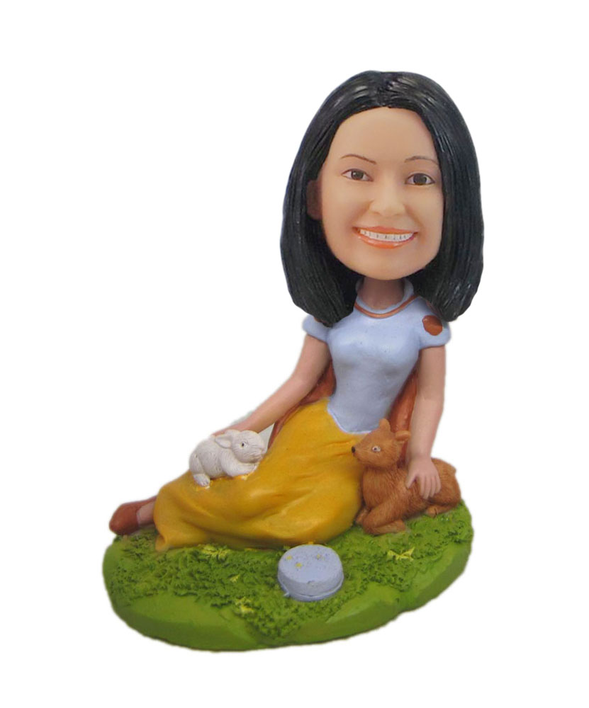 Woman sitting on beach bobblehead doll