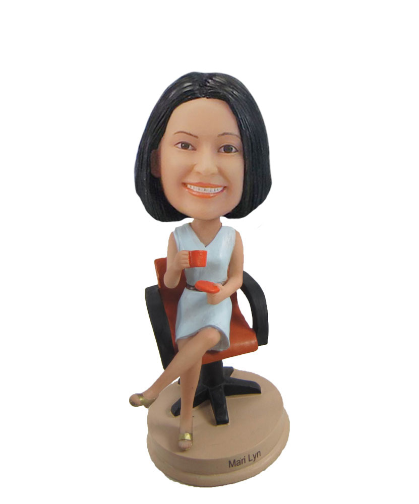 Female bobblehead holding cup on chair F1055